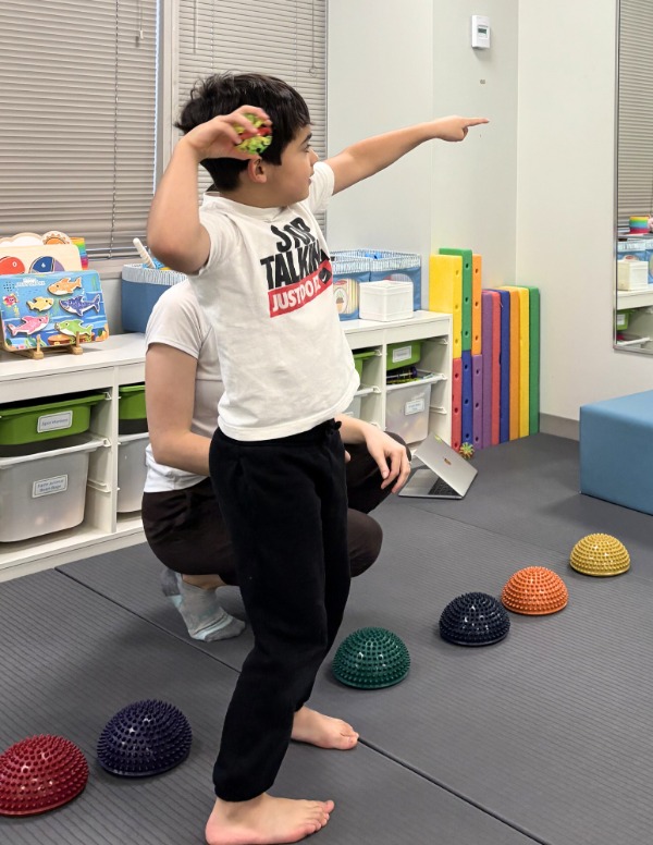 Little League Elbow 2 A child throwing a ball at a physiotherapist session at a Kids Physio Group clinic for little leage elbow